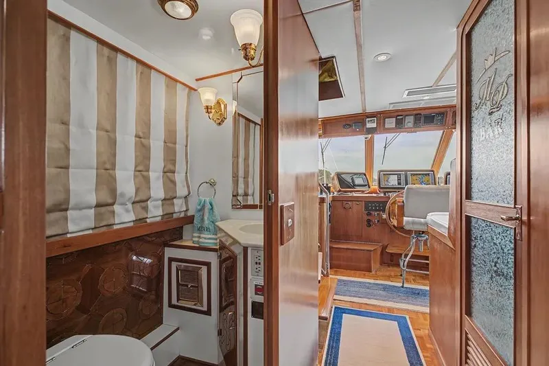 Slide: The Image of Interior of 1989 Jefferson Marquessa 63 yacht, featuring helm and bathroom area. - 10