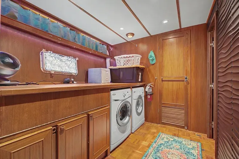 Slide: The Image of Laundry room on 1989 Jefferson Marquessa 63 yacht with washer, dryer, and wooden cabinetry. - 28