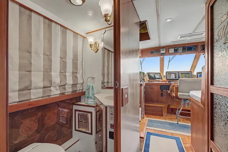 Slide: The Image of Interior of 1989 Jefferson Marquessa 63 yacht showing helm and bathroom area. - 7