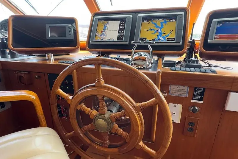 Slide: The Image of Helm of 1989 Jefferson Marquessa 63 yacht with navigation screens and wooden steering wheel. - 2
