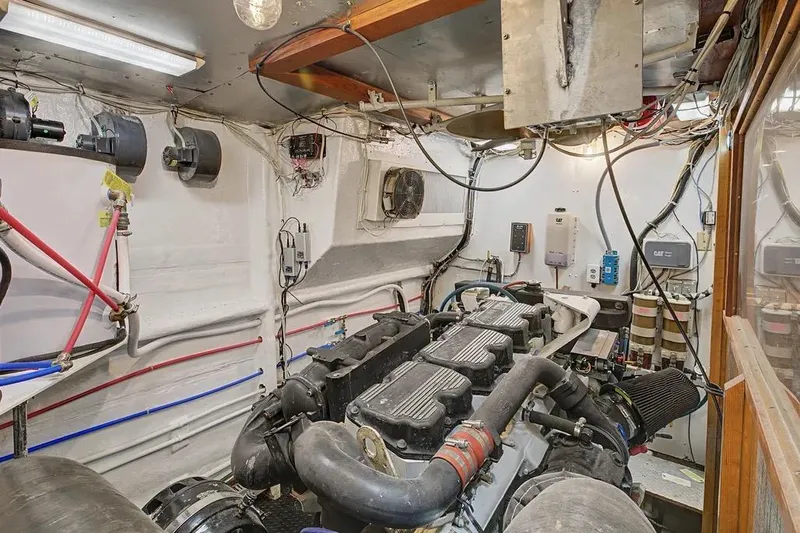 Slide: The Image of Engine room of a 1989 Jefferson Marquessa 63 yacht, showcasing mechanical components and wiring. - 41