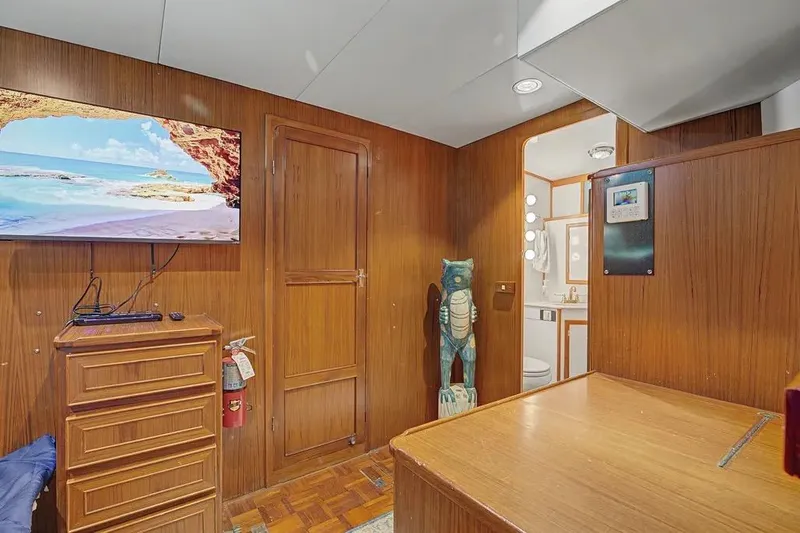 Slide: The Image of Interior of 1989 Jefferson Marquessa 63 yacht with wood paneling, TV, and bathroom access. - 30
