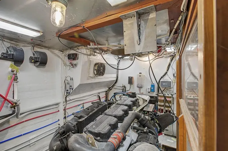 Slide: The Image of Engine room of 1989 Jefferson Marquessa 63 yacht, showcasing mechanical components and wiring. - 39