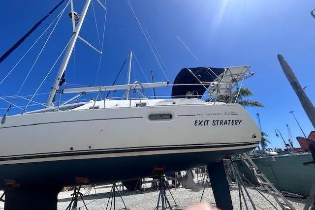 The Image of 2007 Jeanneau Sun Odyssey 42 DS sailboat on stands, named "Exit Strategy," under clear blue sky. - 0