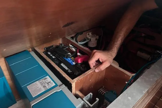 Slide: The Image of Man inspecting battery compartment on 2007 Jeanneau Sun Odyssey 42 DS sailboat. - 11