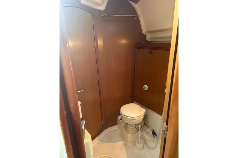 Slide: The Image of 2007 Jeanneau Sun Odyssey 42 DS yacht bathroom with wooden cabinetry and compact toilet. - 16