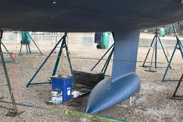 Slide: The Image of 2007 Jeanneau Sun Odyssey 42 DS sailboat keel on stands, with maintenance supplies nearby. - 20