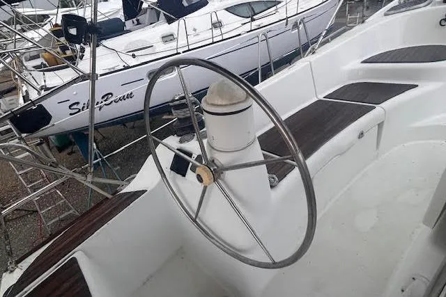 Slide: The Image of Steering wheel of a 2007 Jeanneau Sun Odyssey 42 DS sailboat, docked with other vessels. - 26