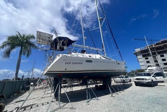 Slide: The Image of 2007 Jeanneau Sun Odyssey 42 DS sailboat on stands, clear sky, palm tree nearby. - 34