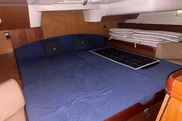 Slide: The Image of Interior cabin of 2007 Jeanneau Sun Odyssey 42 DS with blue bedding and wooden accents. - 5