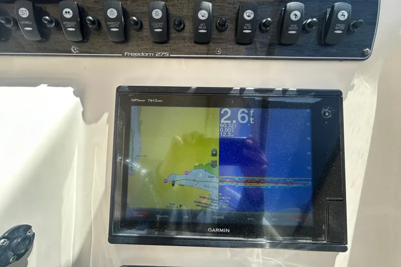 Slide: The Image of Garmin GPS display on 2015 Grady-White Freedom 275 boat dashboard with control switches. - 19