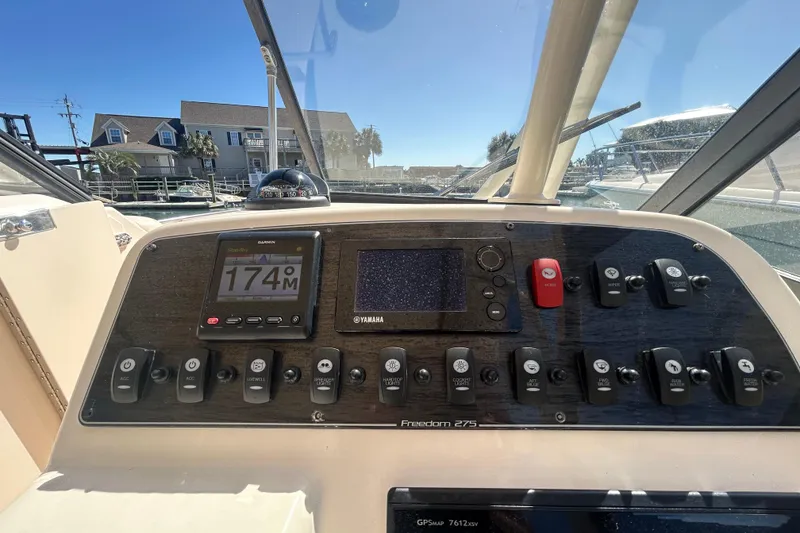 Slide: The Image of 2015 Grady-White Freedom 275 boat dashboard with navigation and control panels. - 20