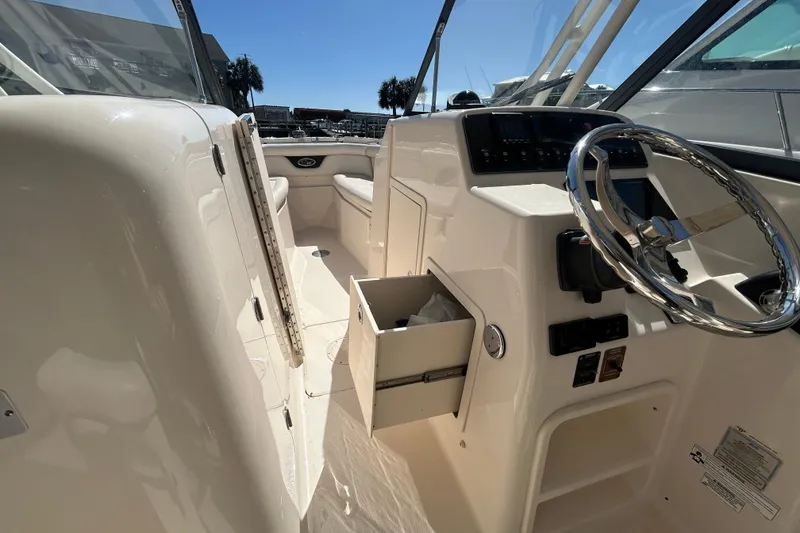 Slide: The Image of 2015 Grady-White Freedom 275 boat interior with steering wheel and console. - 23