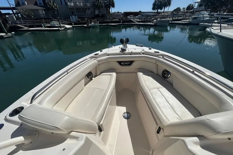 Slide: The Image of 2015 Grady-White Freedom 275 boat interior with white seating in a marina. - 24