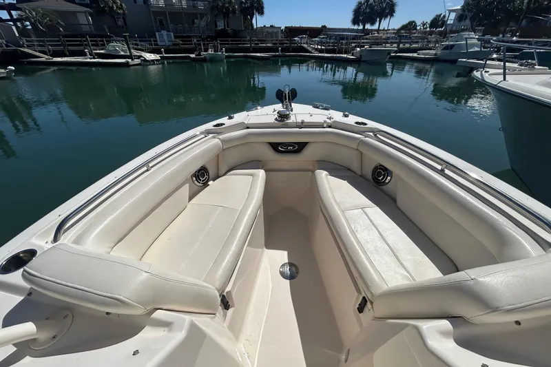 Slide: The Image of 2015 Grady-White Freedom 275 boat interior with white seating in a marina. - 25