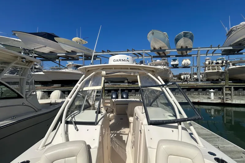 Slide: The Image of 2015 Grady-White Freedom 275 boat docked, surrounded by other boats in a marina. - 28