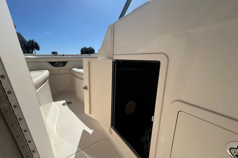 Slide: The Image of 2015 Grady-White Freedom 275 boat interior with open storage compartment under sunny sky. - 30