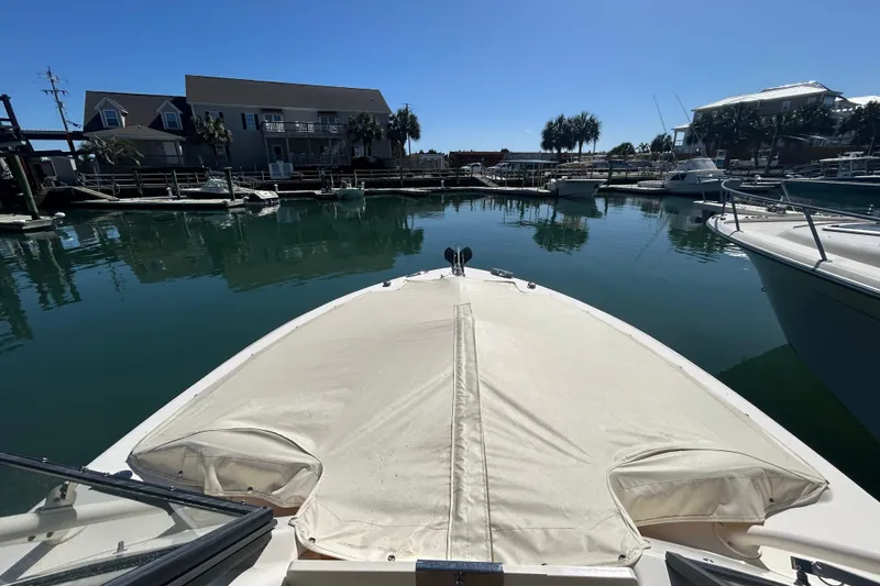Slide: The Image of 2015 Grady-White Freedom 275 boat docked in a serene marina setting. - 32
