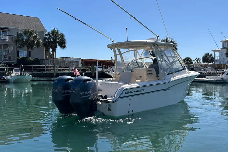 Slide: The Image of 2015 Grady-White Freedom 275 boat with twin Yamaha engines in a marina setting. - 4