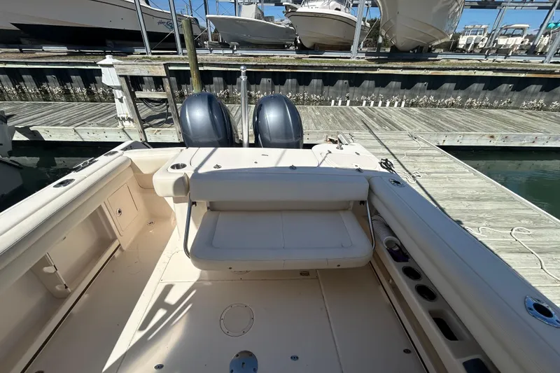 Slide: The Image of 2015 Grady-White Freedom 275 boat interior at dock, featuring dual outboard motors. - 7