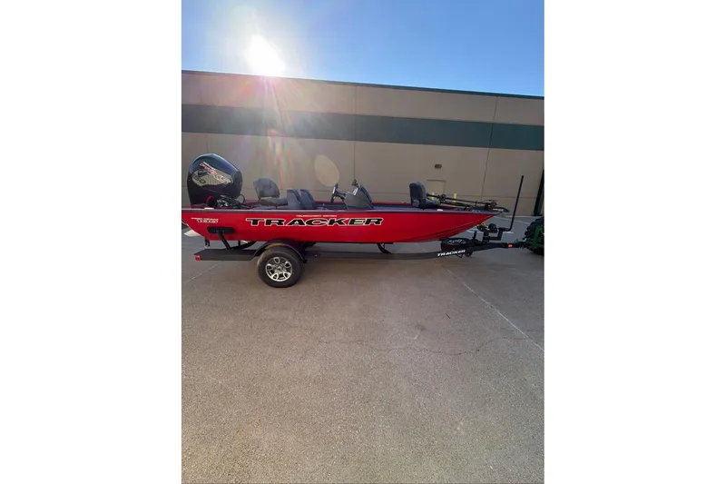 The Image of 2026 Tracker Pro Team 195 boat in vibrant red on a trailer, parked outdoors. - 0