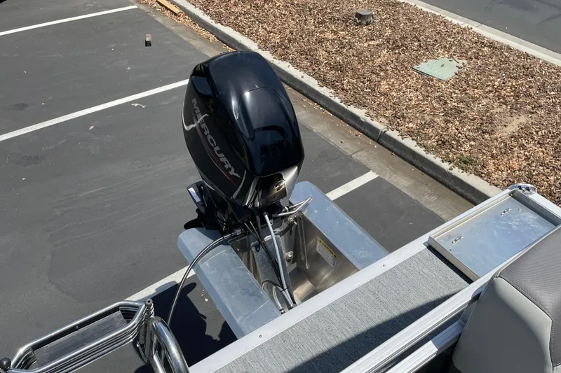 Slide: The Image of 2026 Sun Tracker Bass Buggy 16 XL Select with Mercury outboard motor in parking lot. - 23