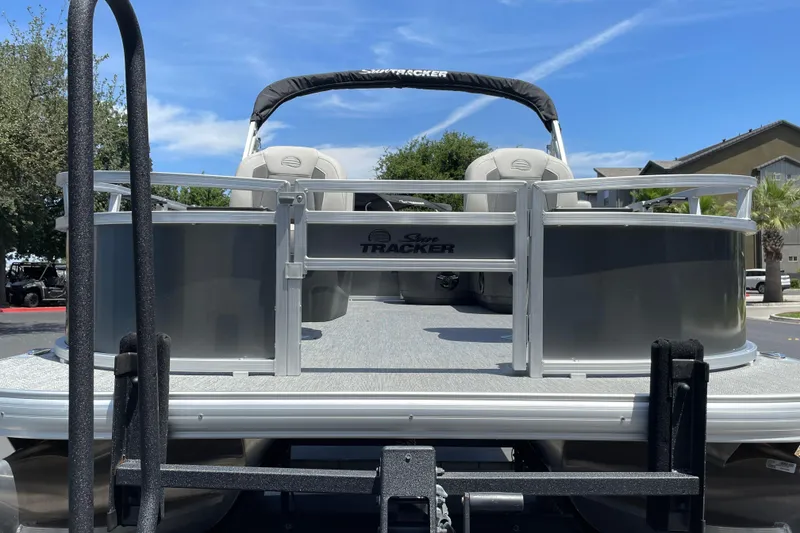Slide: The Image of 2026 Sun Tracker Bass Buggy 16 XL Select pontoon boat on trailer, sunny day. - 6