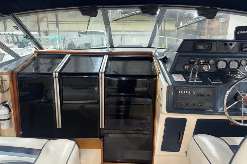Slide: The Image of 1986 Sea Ray 340 Express Cruiser cockpit with steering wheel and control panel. - 10