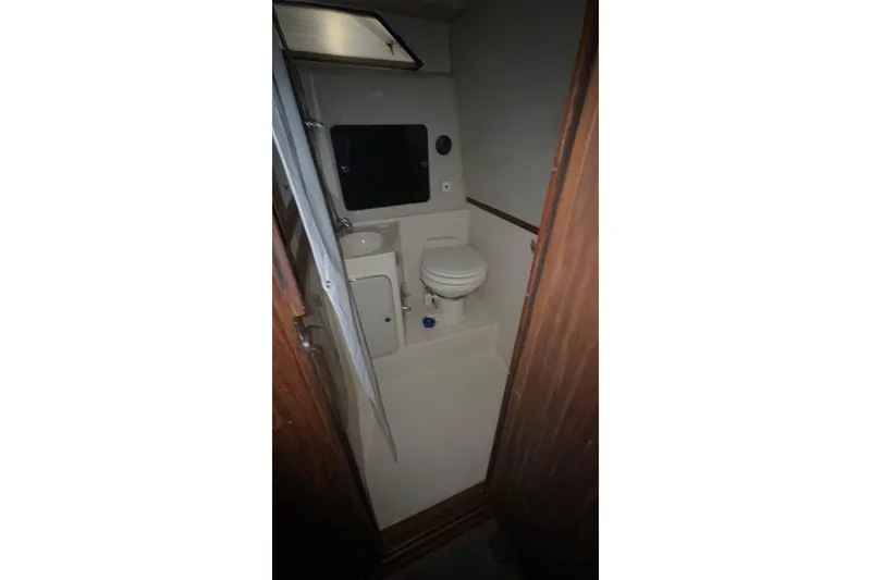 Slide: The Image of 1986 Sea Ray 340 Express Cruiser bathroom interior with toilet and sink. - 12