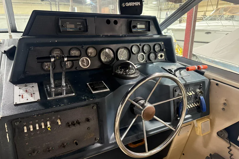 Slide: The Image of 1986 Sea Ray 340 Express Cruiser helm with gauges, steering wheel, and controls. - 18