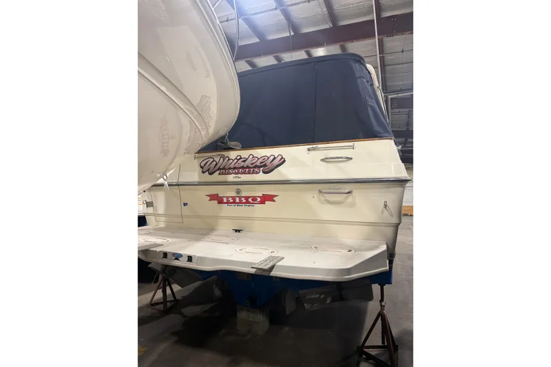 Slide: The Image of 1986 Sea Ray 340 Express Cruiser in storage, featuring custom "Whiskey Biscuits" and "BBQ" decals. - 20