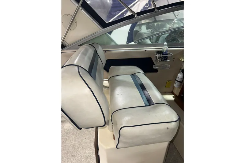 Slide: The Image of 1986 Sea Ray 340 Express Cruiser interior seating with cup holder and fire extinguisher. - 9