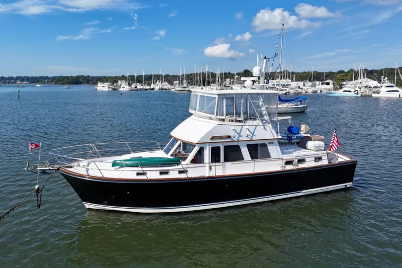 The Image of 1997 Sabre Sabreline 47 yacht docked in a marina, under a clear blue sky. - 1
