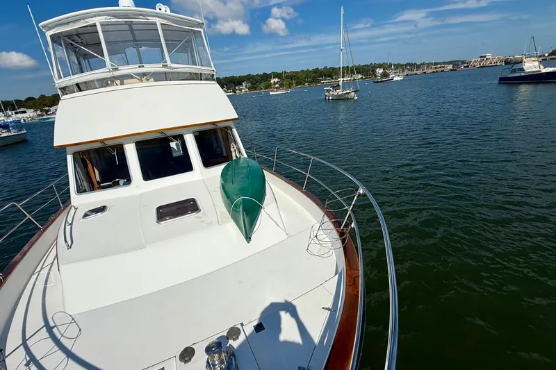 Slide: The Image of 1997 Sabre Sabreline 47 yacht on calm water, clear sky, and nearby boats. - 18