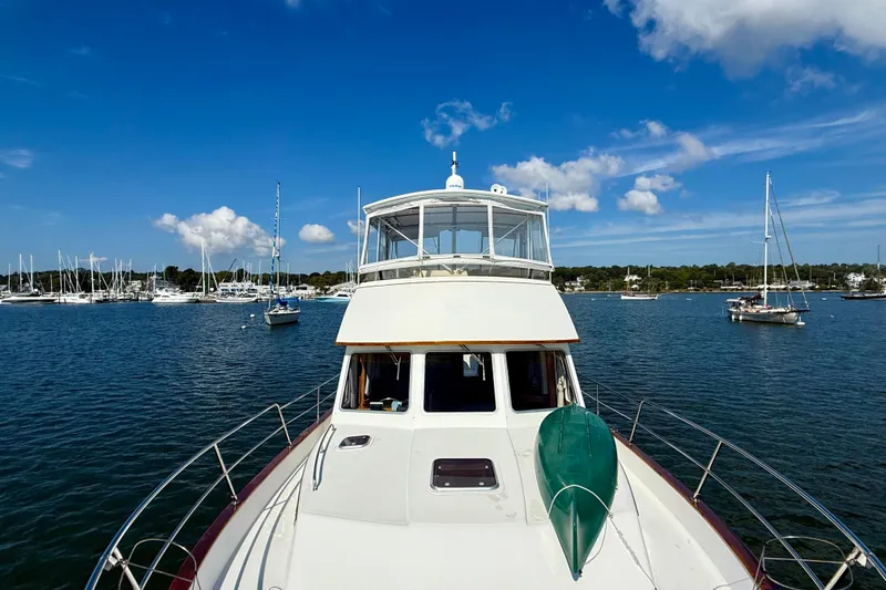 Slide: The Image of 1997 Sabre Sabreline 47 yacht on calm waters, surrounded by sailboats under a clear blue sky. - 19