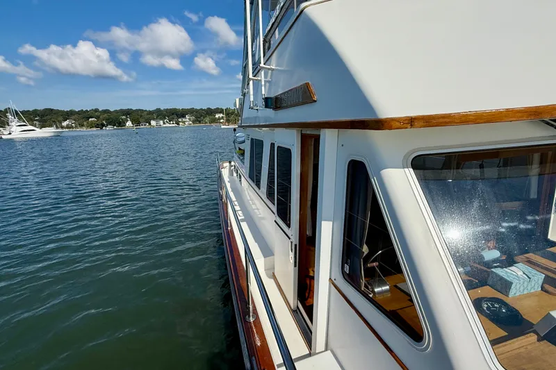 Slide: The Image of 1997 Sabre Sabreline 47 yacht on calm water, showcasing sleek design and scenic backdrop. - 22