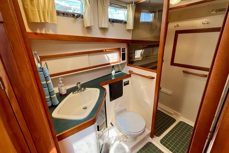 Slide: The Image of Bathroom interior of 1997 Sabre Sabreline 47 yacht with sink, toilet, and wooden accents. - 41