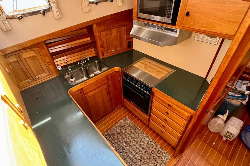 Slide: The Image of 1997 Sabre Sabreline 47 yacht kitchen with wood cabinetry and modern appliances. - 45