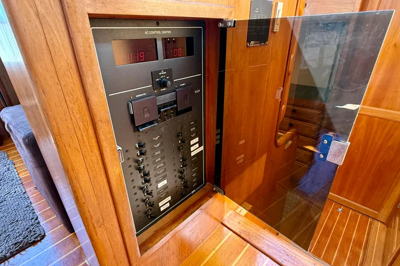 Slide: The Image of Electrical control panel inside 1997 Sabre Sabreline 47 yacht, featuring wooden cabinetry. - 51