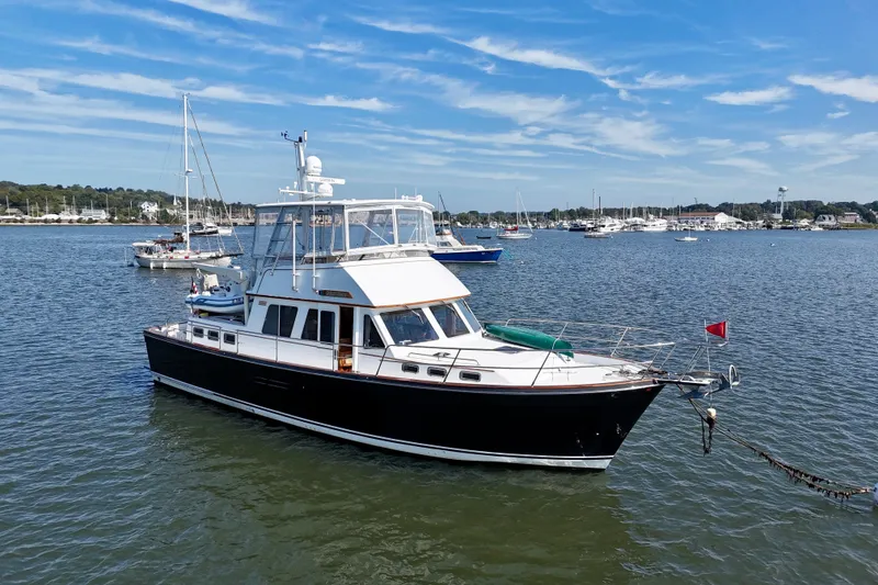 Slide: The Image of 1997 Sabre Sabreline 47 yacht anchored in a scenic harbor with sailboats. - 6