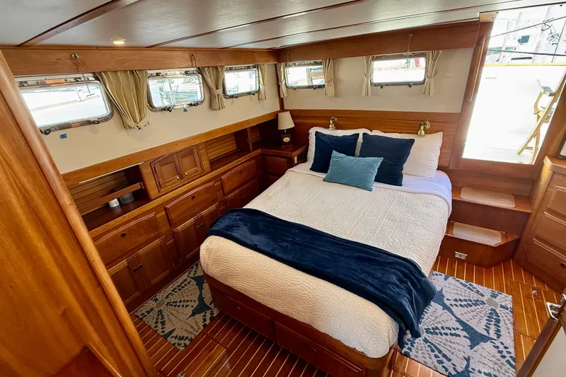 Slide: The Image of Luxurious 1997 Sabreline 47 yacht bedroom with wood paneling and cozy bedding. - 64
