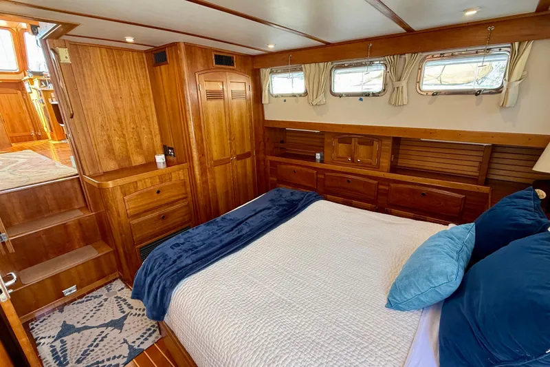 Slide: The Image of Luxurious 1997 Sabreline 47 yacht cabin with wooden interior and cozy bedding. - 65