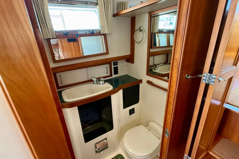 Slide: The Image of 1997 Sabre Sabreline 47 yacht bathroom with wooden cabinetry and compact design. - 68