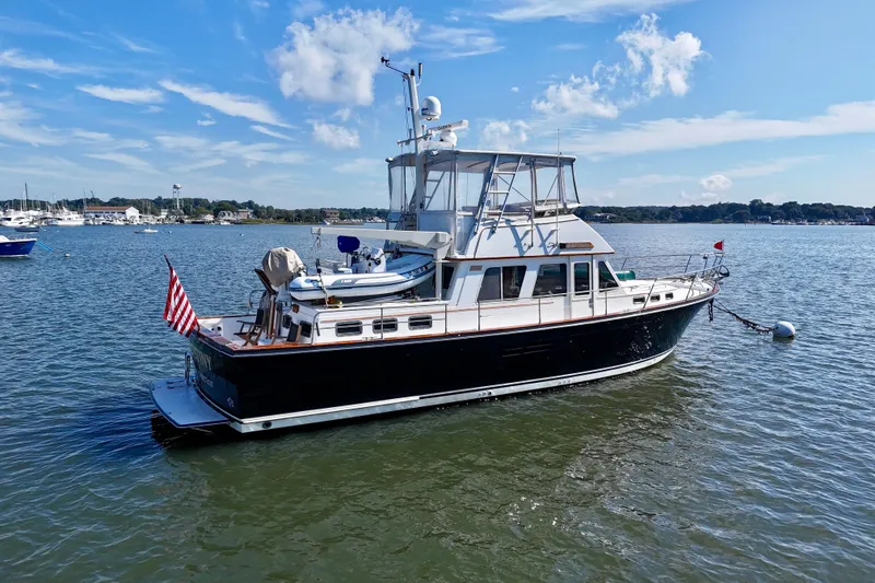 Slide: The Image of 1997 Sabre Sabreline 47 yacht moored on calm water under a clear blue sky. - 8