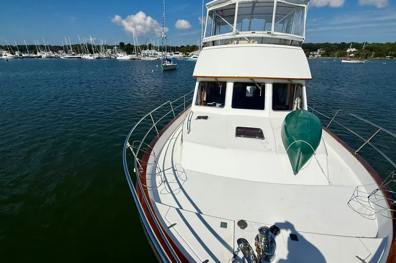 Slide: The Image of 1997 Sabre Sabreline 47 yacht on calm water, with marina and blue sky background. - 17