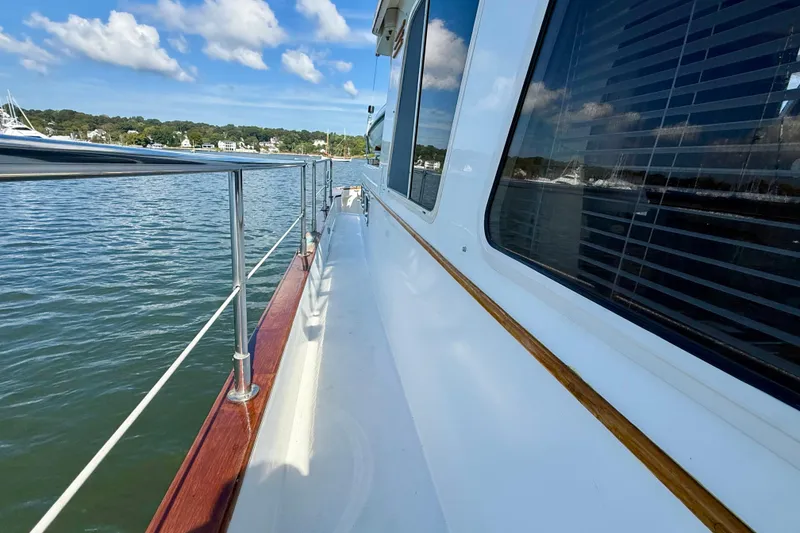 Slide: The Image of Side view of 1997 Sabreline 47 yacht on calm water under blue sky. - 23