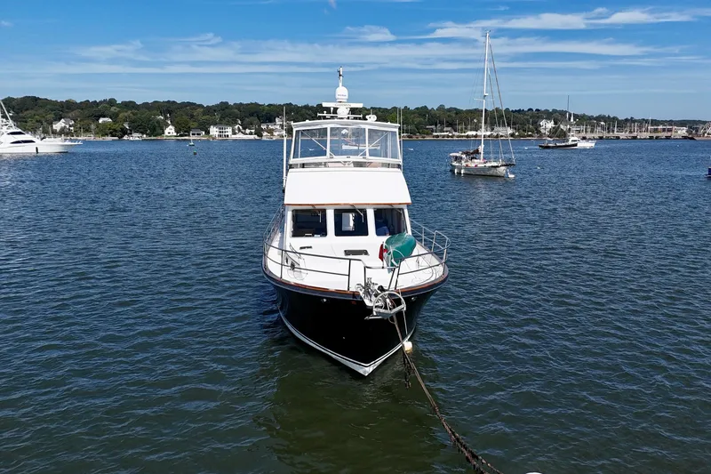 Slide: The Image of Sabreline 47 yacht from 1997 anchored in a scenic harbor with sailboats. - 4