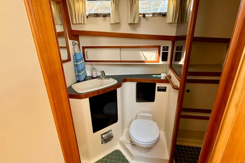 Slide: The Image of Bathroom interior of 1997 Sabreline 47 yacht with sink, toilet, and wooden accents. - 44