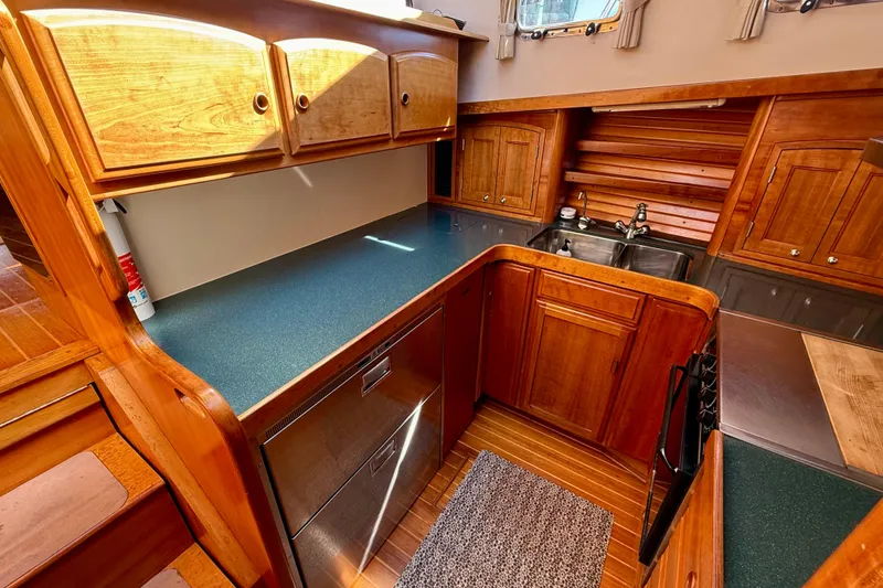 Slide: The Image of 1997 Sabre Sabreline 47 yacht kitchen with wooden cabinetry and modern appliances. - 49