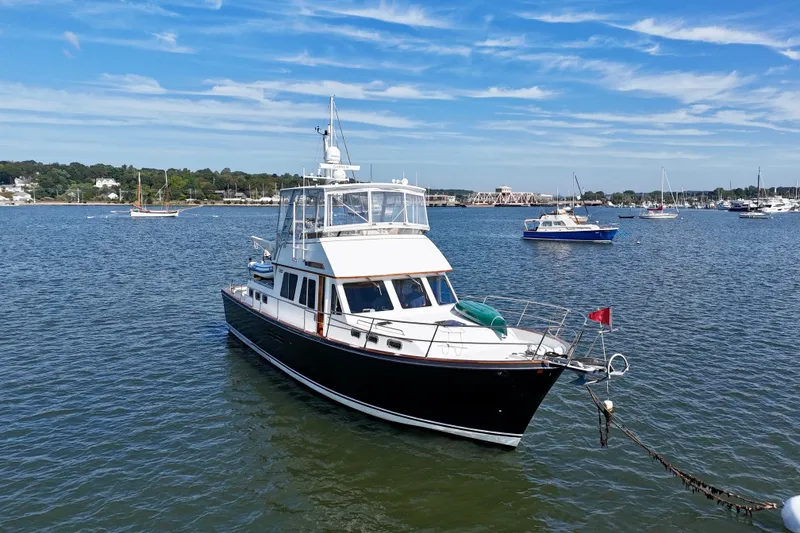 Slide: The Image of 1997 Sabre Sabreline 47 yacht anchored in a scenic harbor with blue skies. - 5